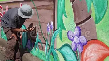 墙画家在混凝土墙上画一个花园。